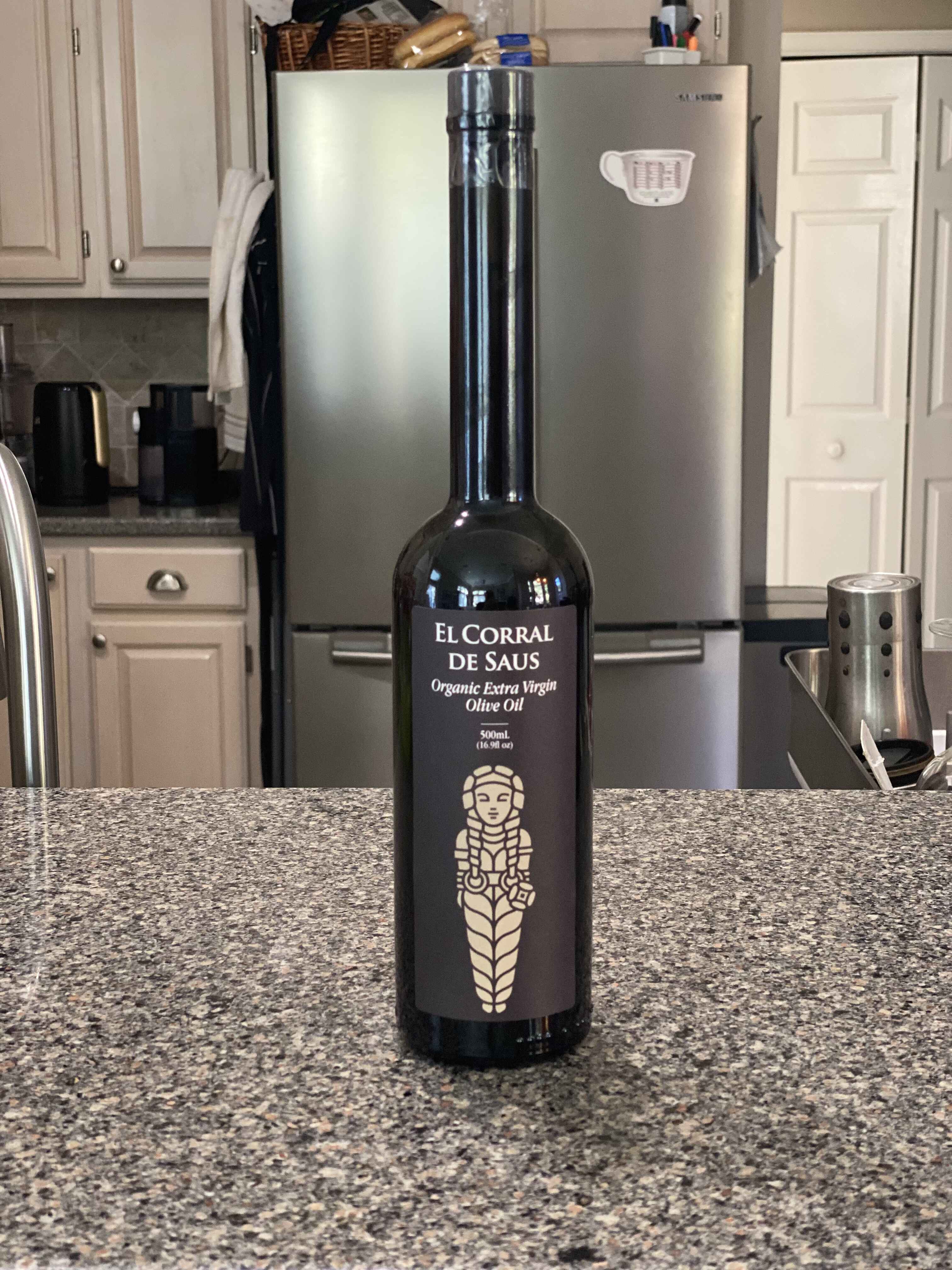 Bottle of El Corral de Saus olive oil on a kitchen counter